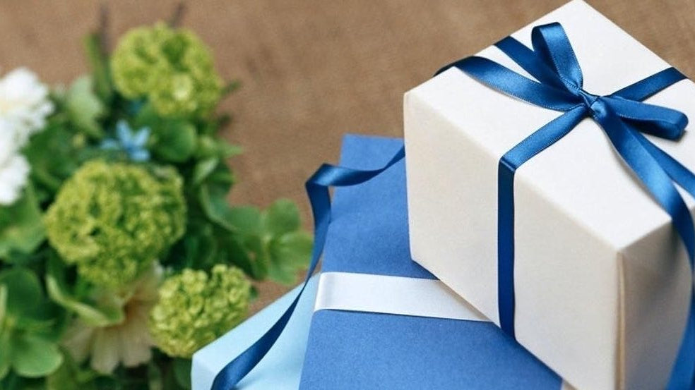 Wedding gifts wrapped and stacked in blue boxes with ribbon