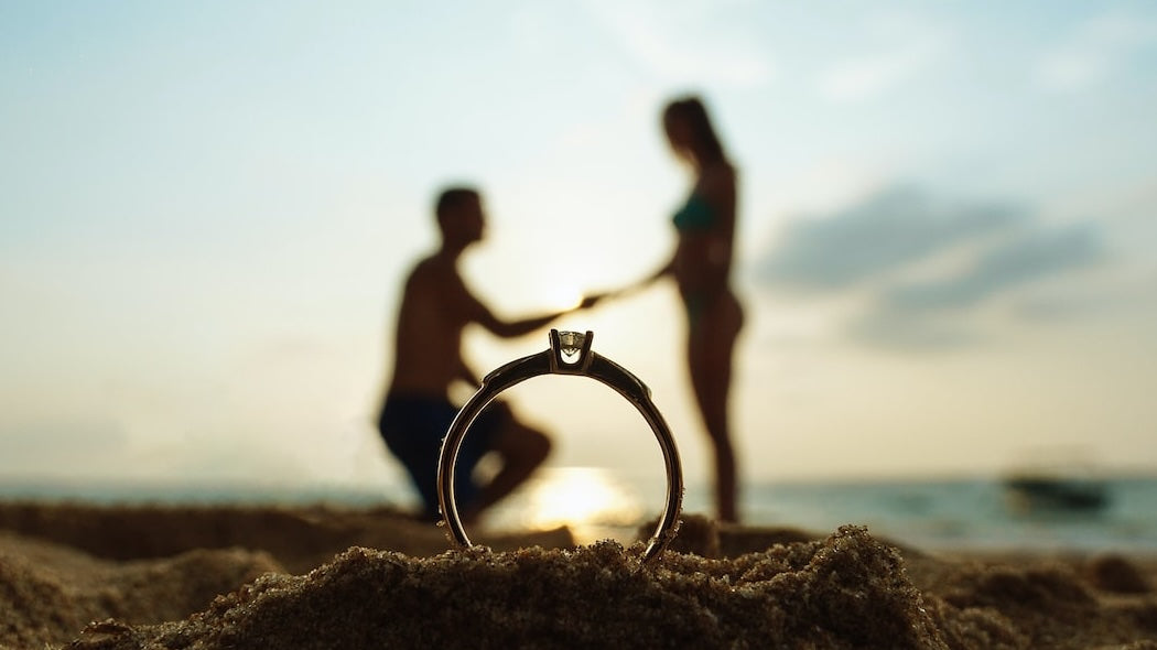 Honeymoon couple hold hands with engagement ring infront.