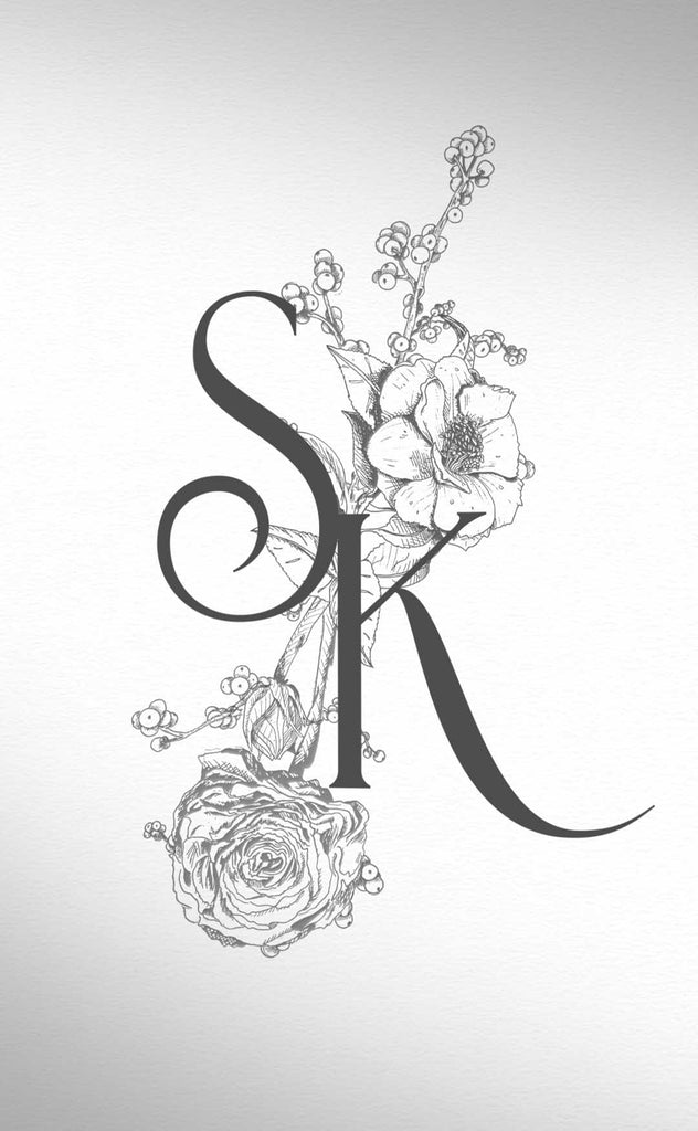 Black and white vintage flower botanicals are arranged in an elegant bouquet behind a stylish handwritten monogram featuring the listers S K