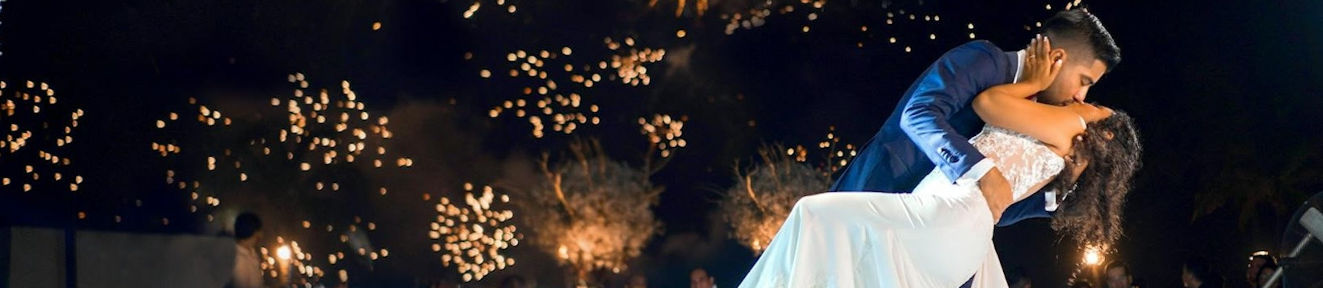 Wedding couple kissing with fire works behind. 