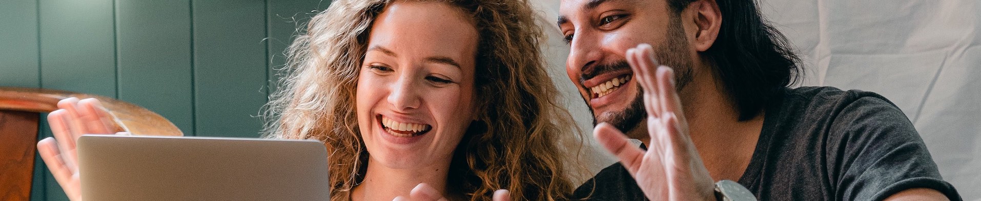 Happy couple editing on a laptop