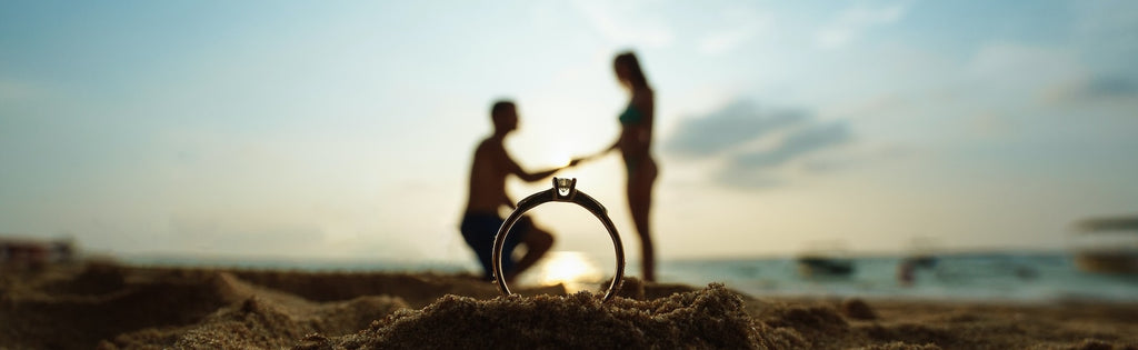 Honeymoon couple hold hands with engagement ring infront.