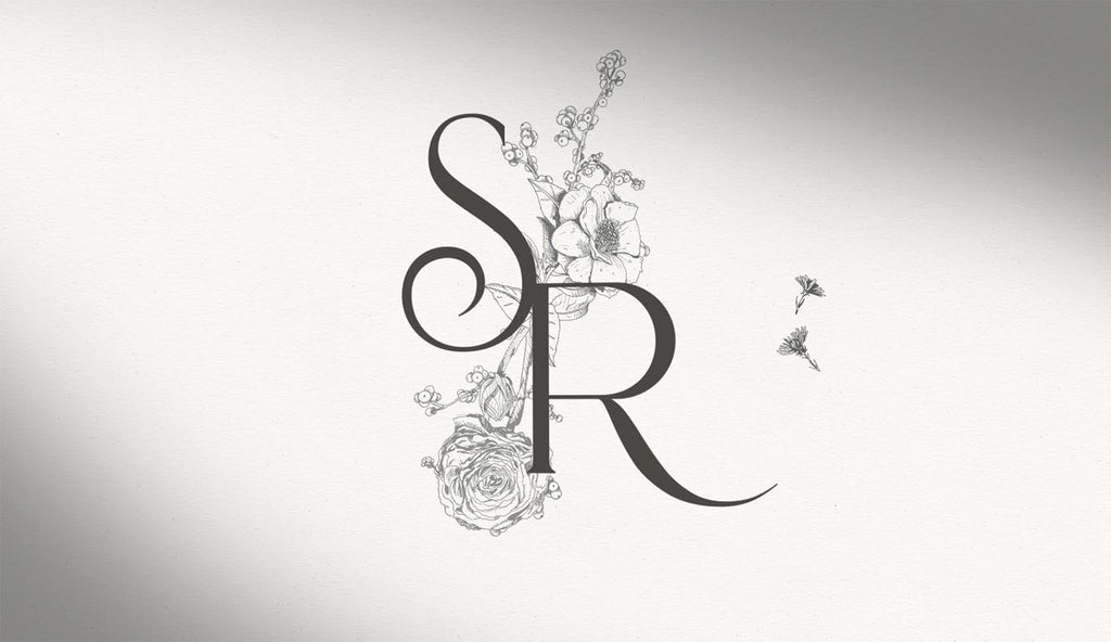 Monogram of SR with illustrated botanical flowers behind it.