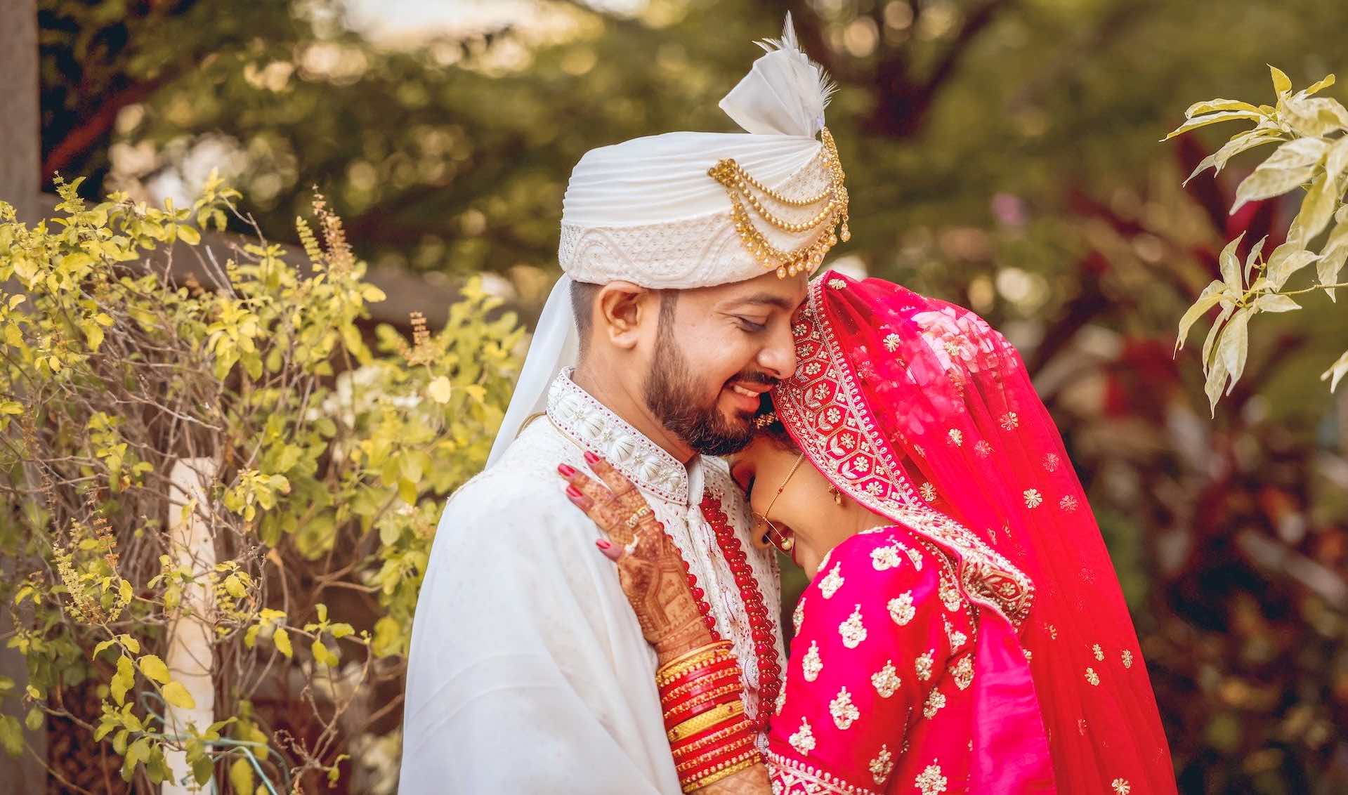 Indian Bride and Groom in traditional dress embrace at their Wedding ceremony