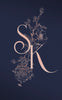 Beautiful pink wedding monogram with pink floral illustrations over a navy background. 